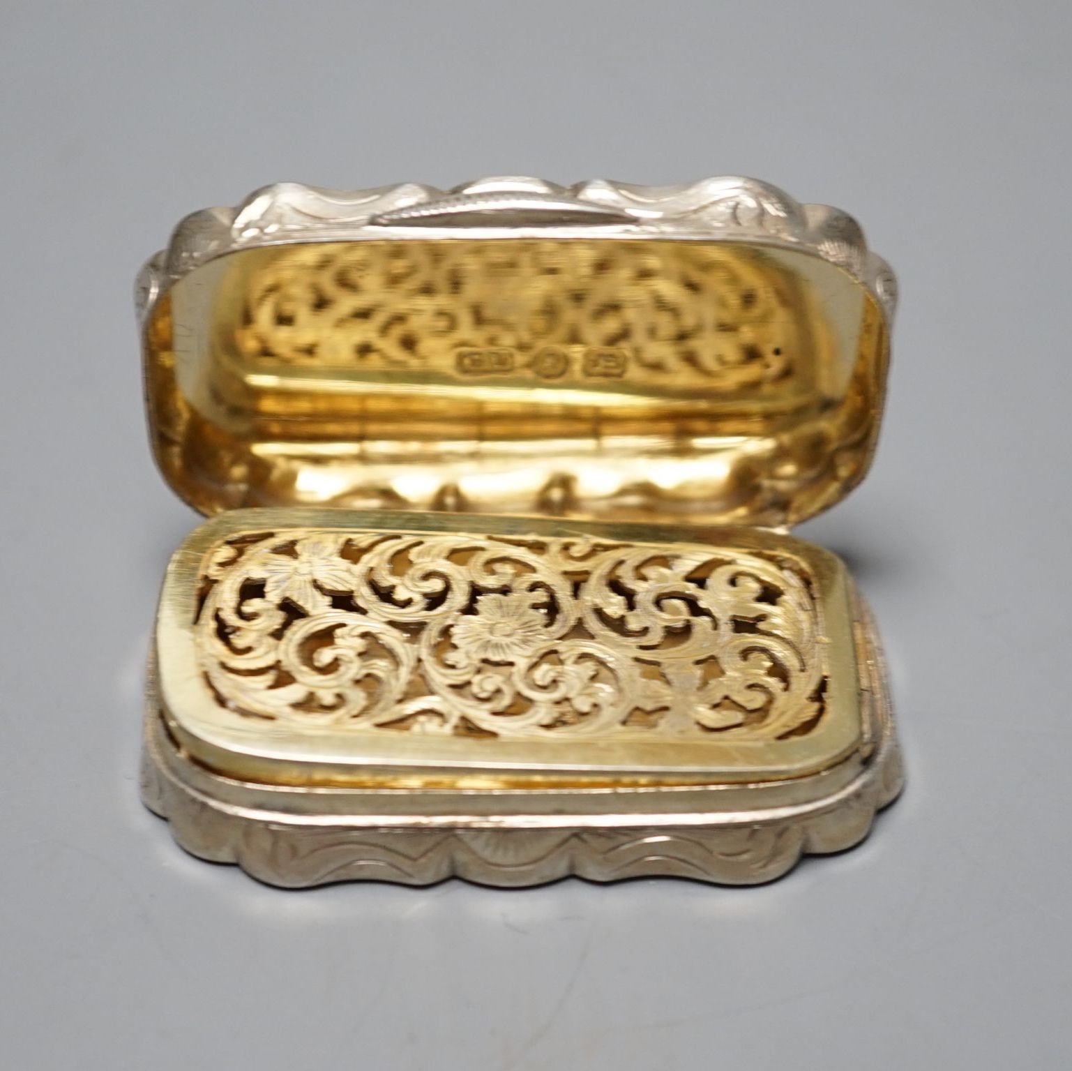 A Victorian engine turned silver shaped oval vinaigrette, by George Unite, Birmingham, 1868, 54mm.